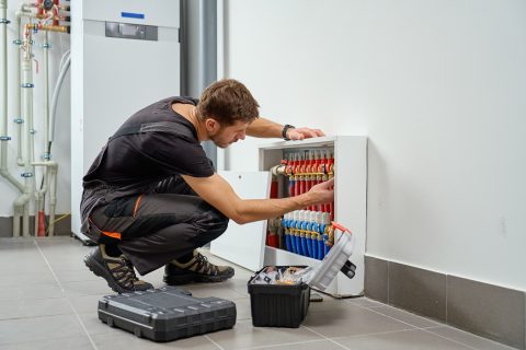 Technicus werkt geknield aan een verdelerinstallatie